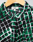 Display of black, green and white geometric print dress