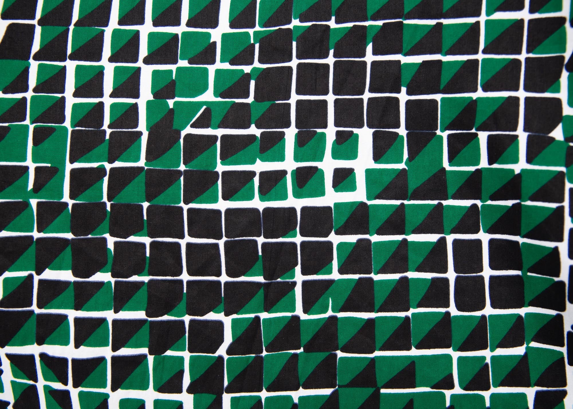 Close up display of black, green and white geometric print dress