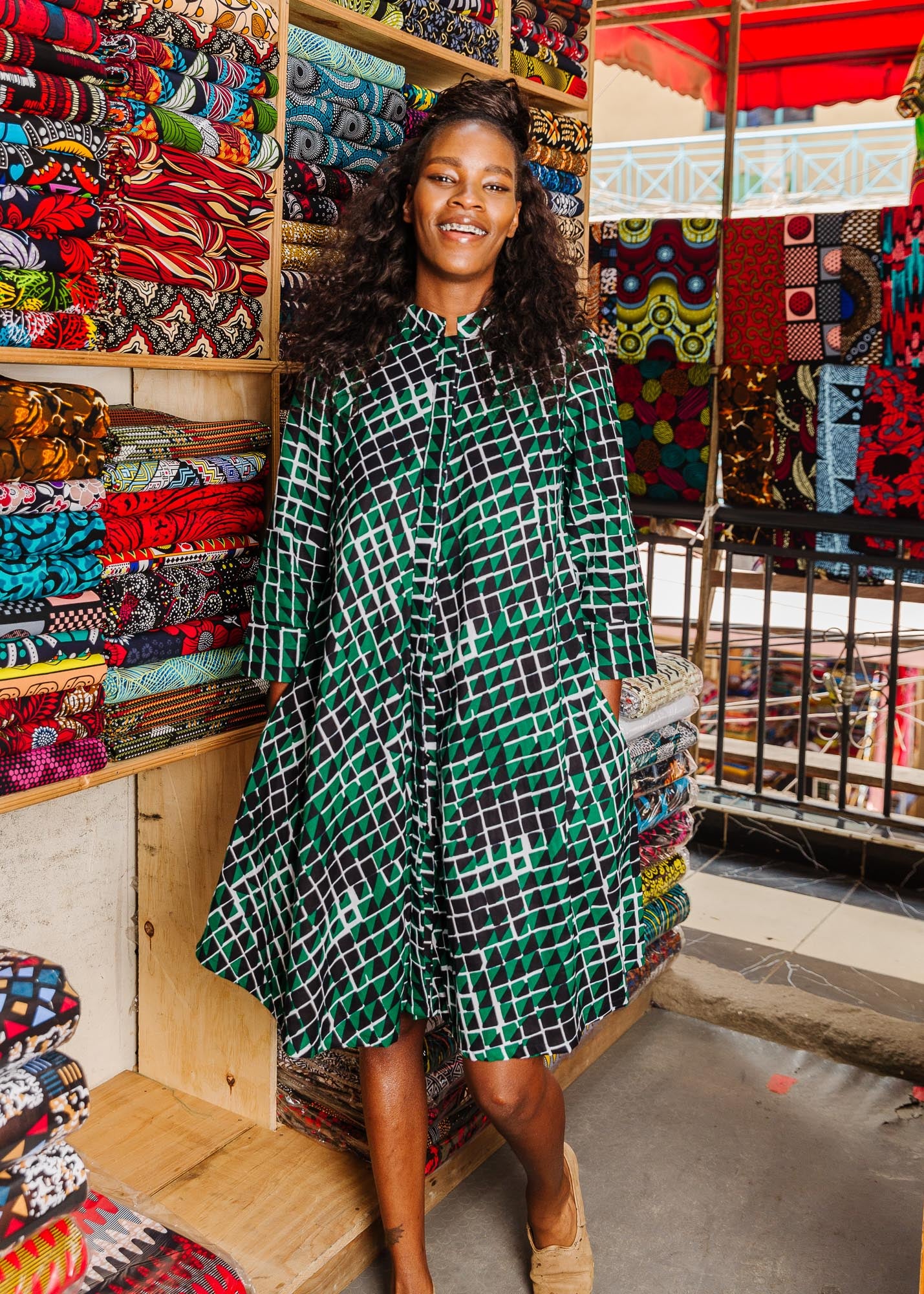 The model is wearing black, green and white geometric print dress