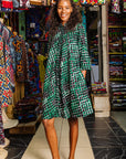 The model is wearing black, green and white geometric print dress
