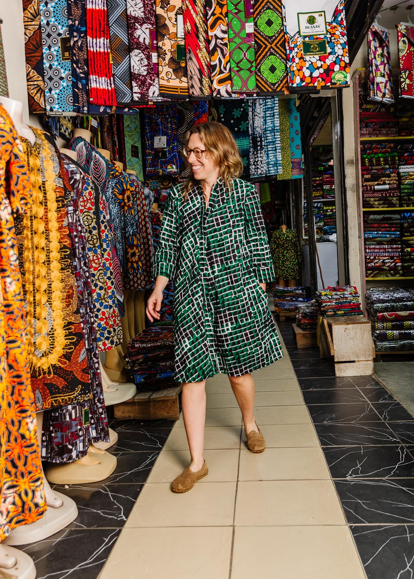 The model is wearing black, green and white geometric print dress