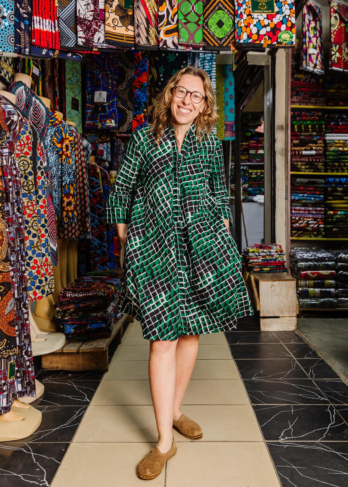 The model is wearing black, green and white geometric print dress