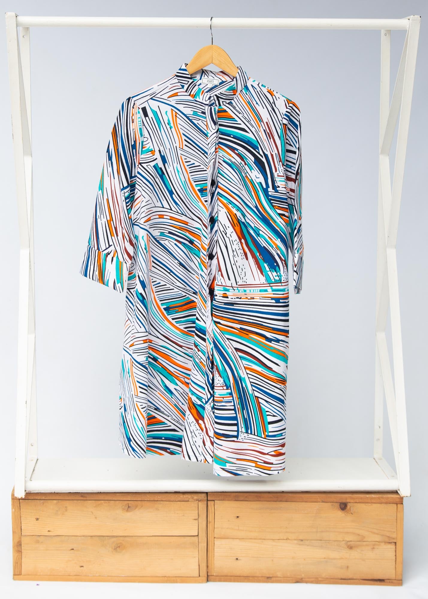 Display of white, black, orange, blue, aqua and brown abstract print dress