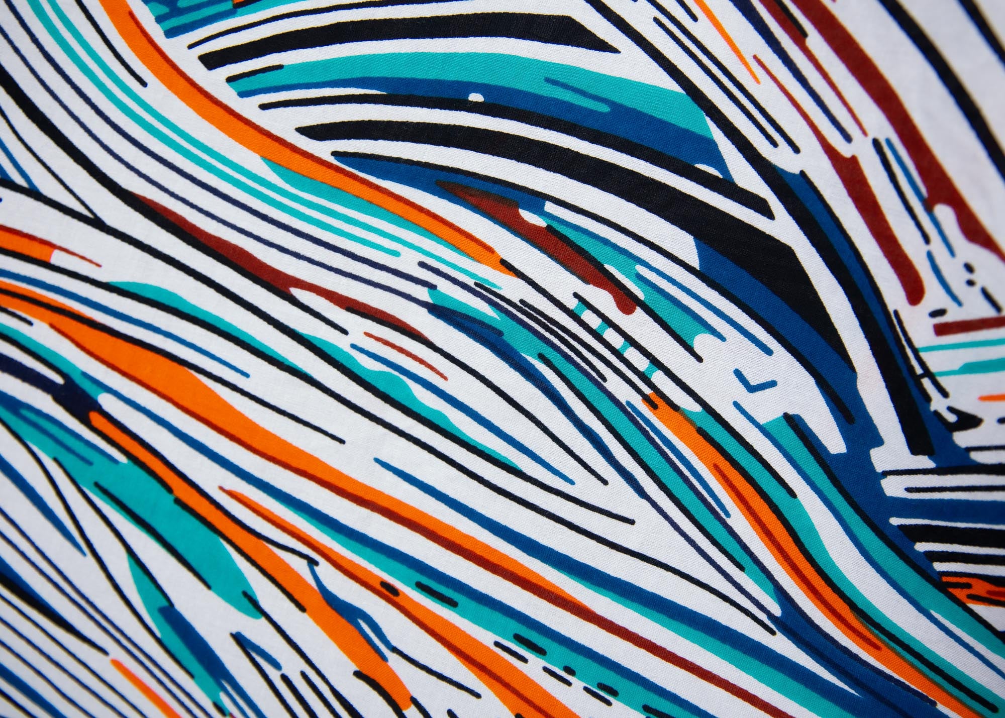Close up display of white, black, orange, blue, aqua and brown abstract print dress