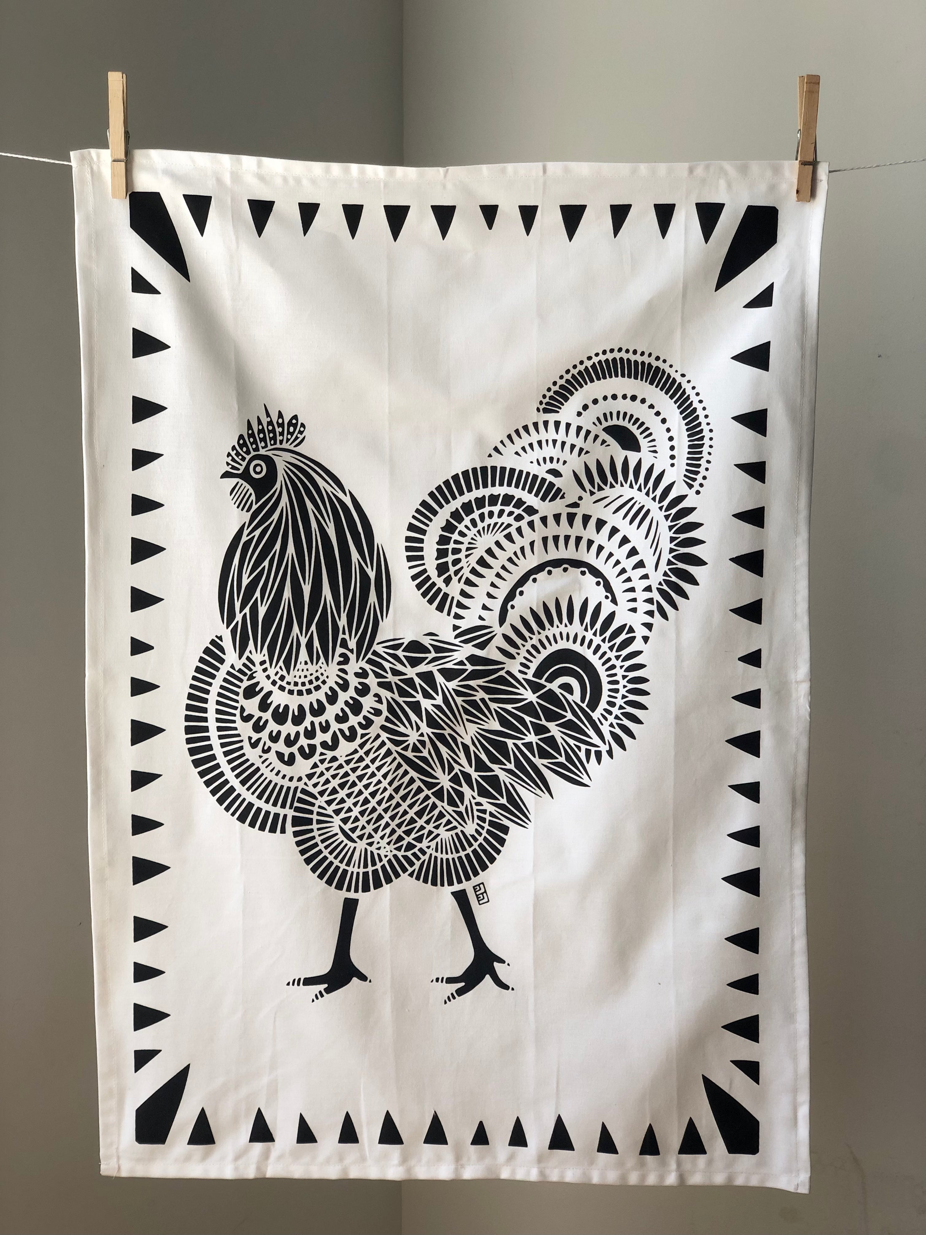 Display of tea towel with rooster print.