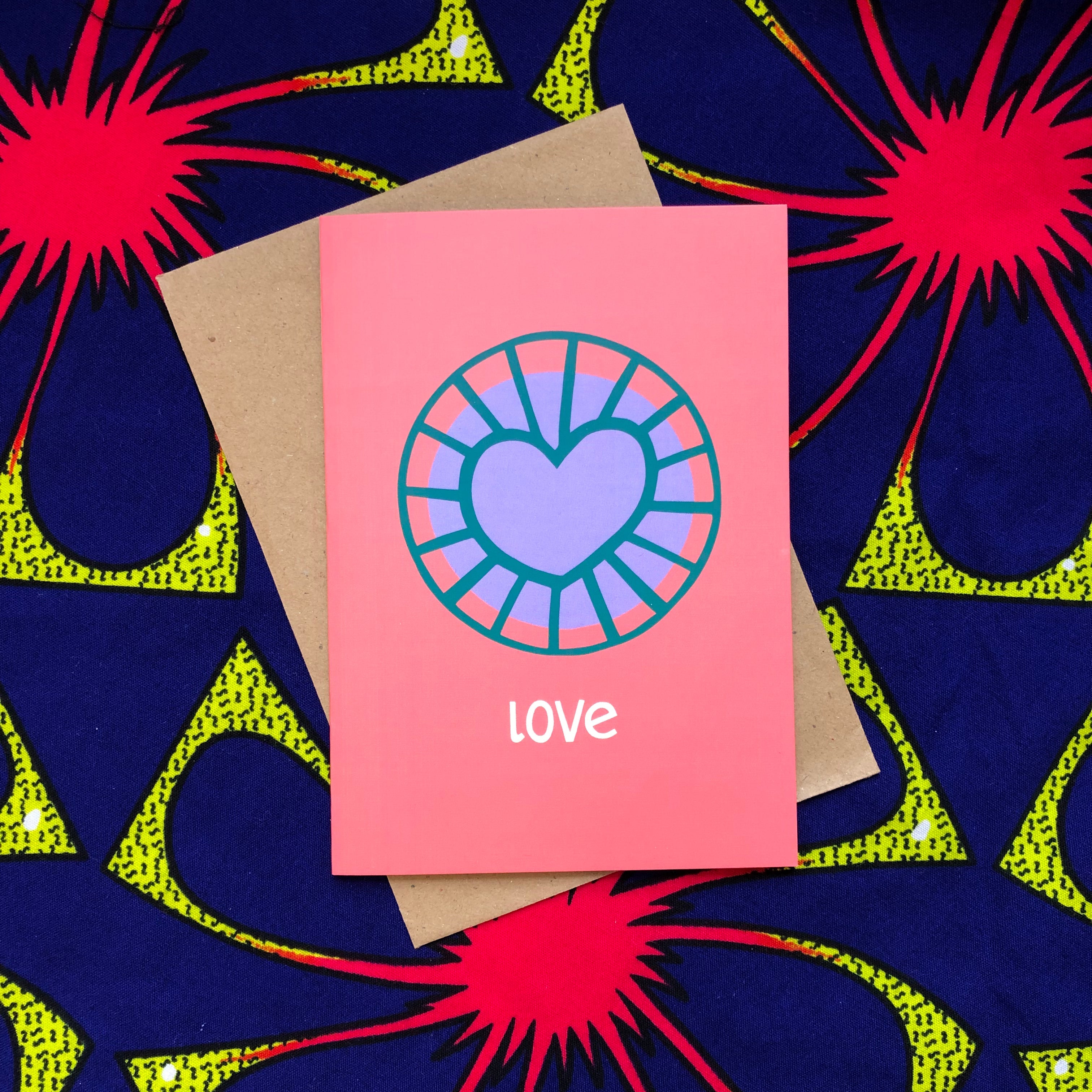 Coral color greeting card with purple and blue heart.
