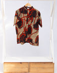 Display of beige shirt with brown and orange circles and lines.