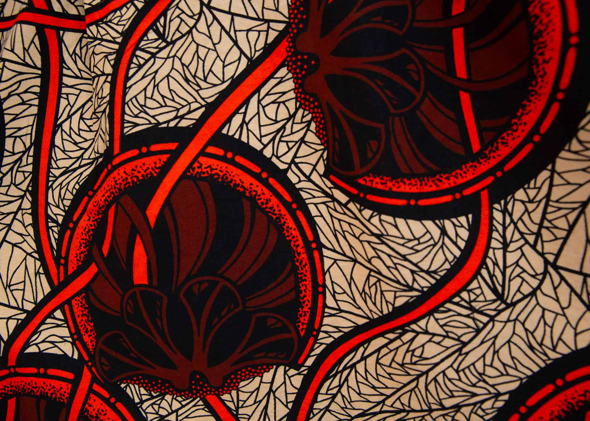Close up display of beige shirt with brown and orange circles and lines, fabric.