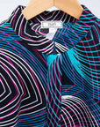 Display of black dress with colorful peacock feather print..