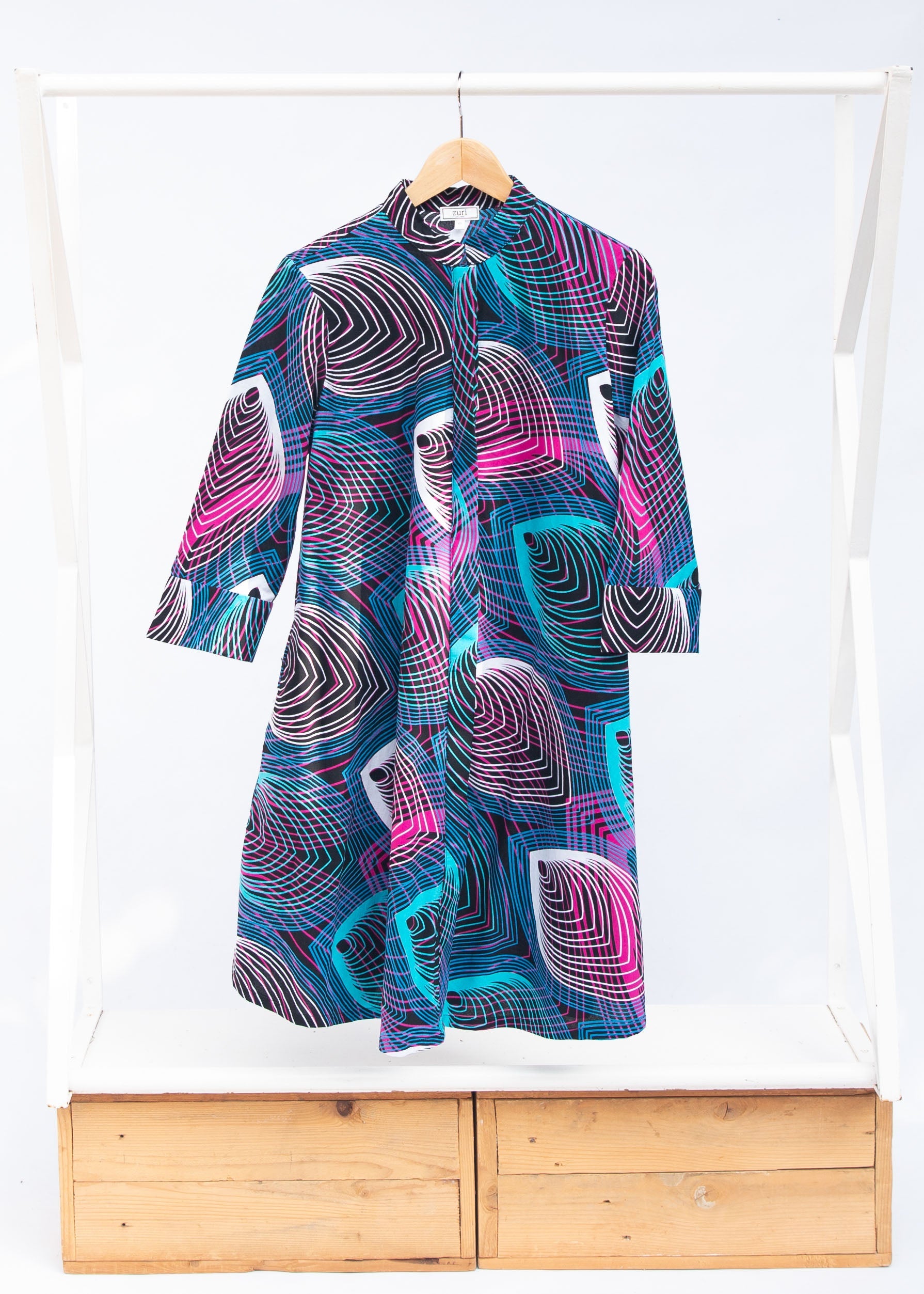 Display of black dress with colorful peacock feather print..
