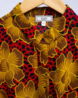 Display of red dress with yellow and brown flowers.
