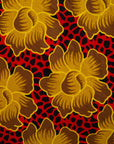 Close up display of red dress with yellow and brown flowers, fabric.
