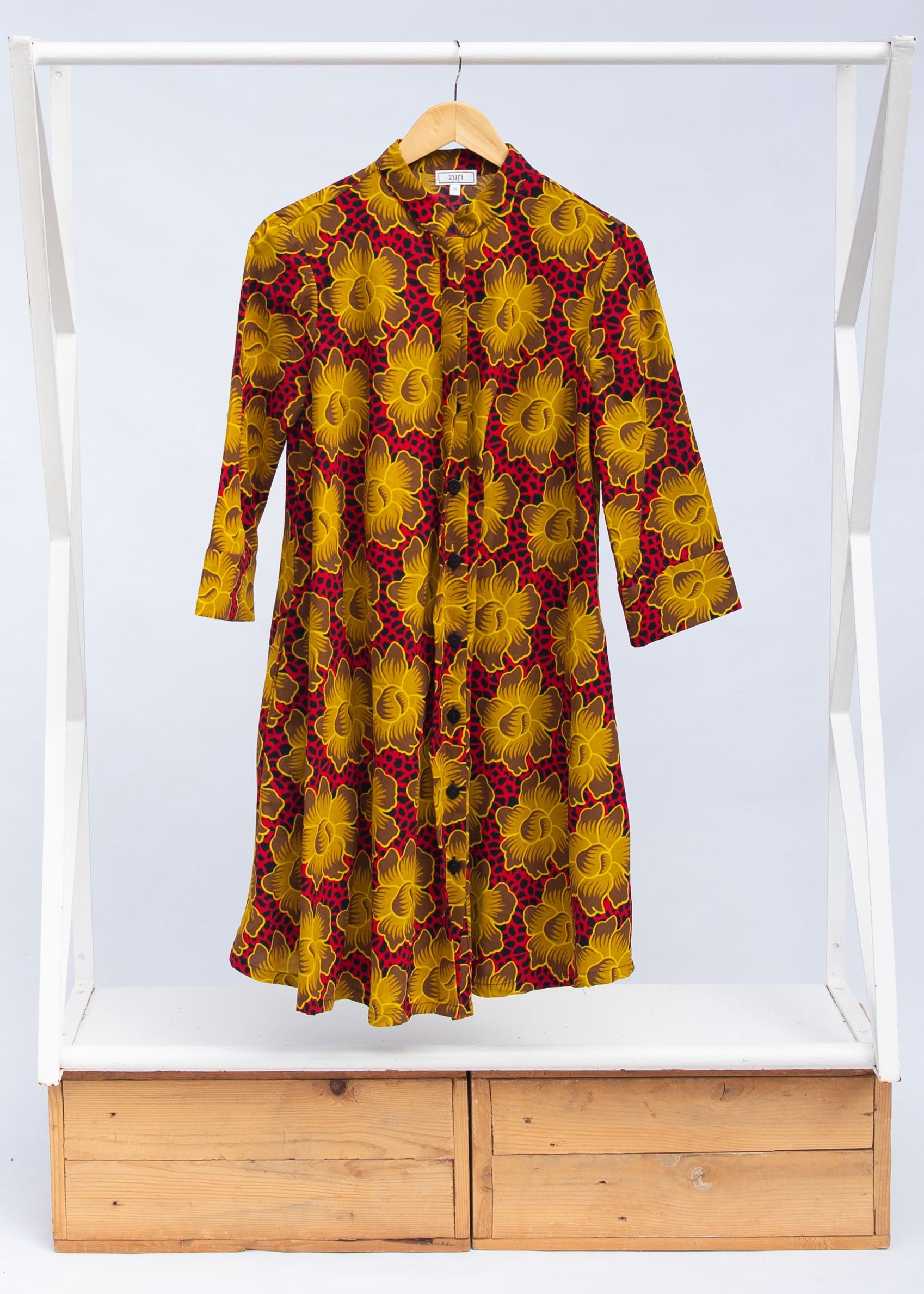 Display of red dress with yellow and brown flowers.
