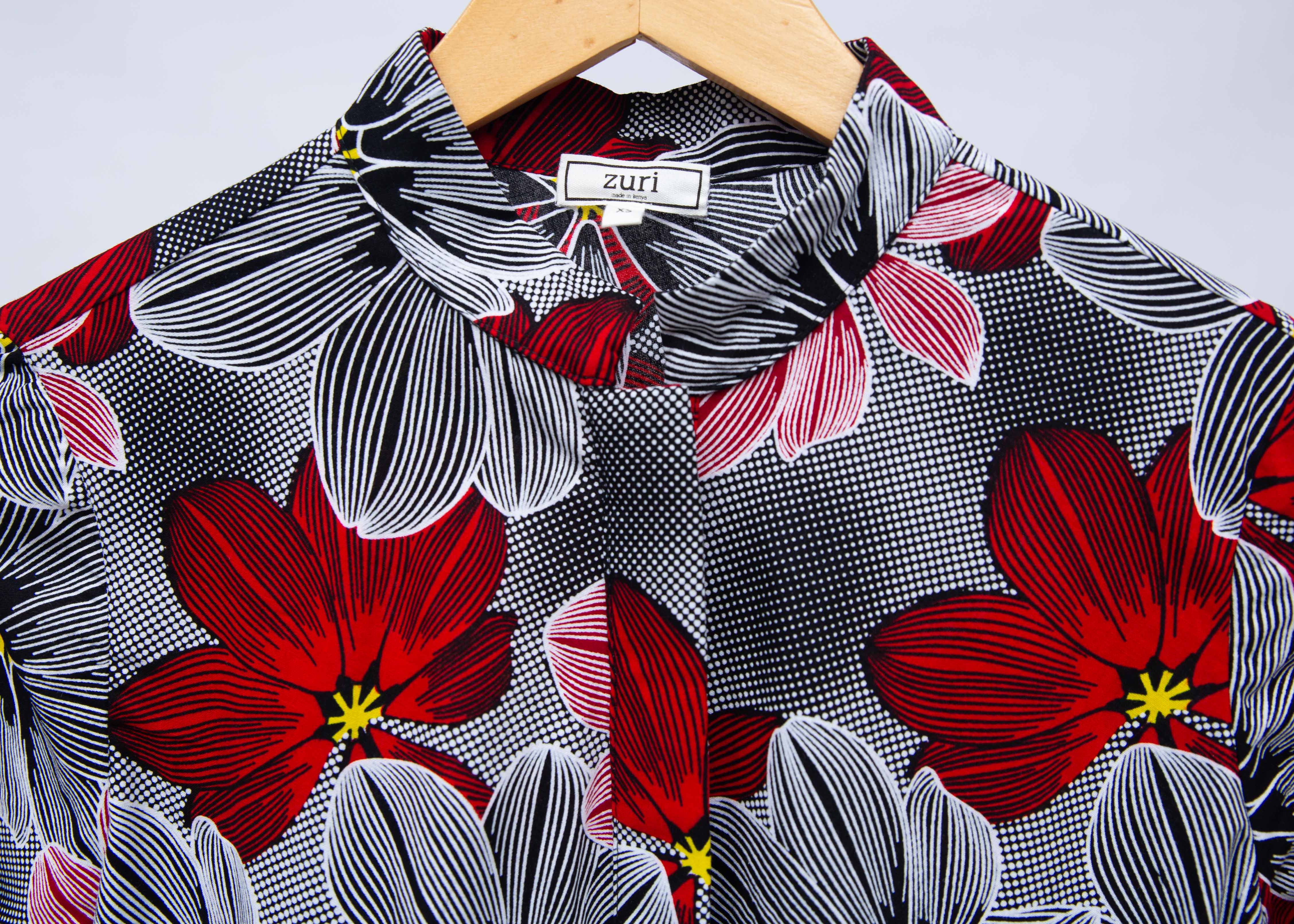 Display of dress with large grey and red flower print.