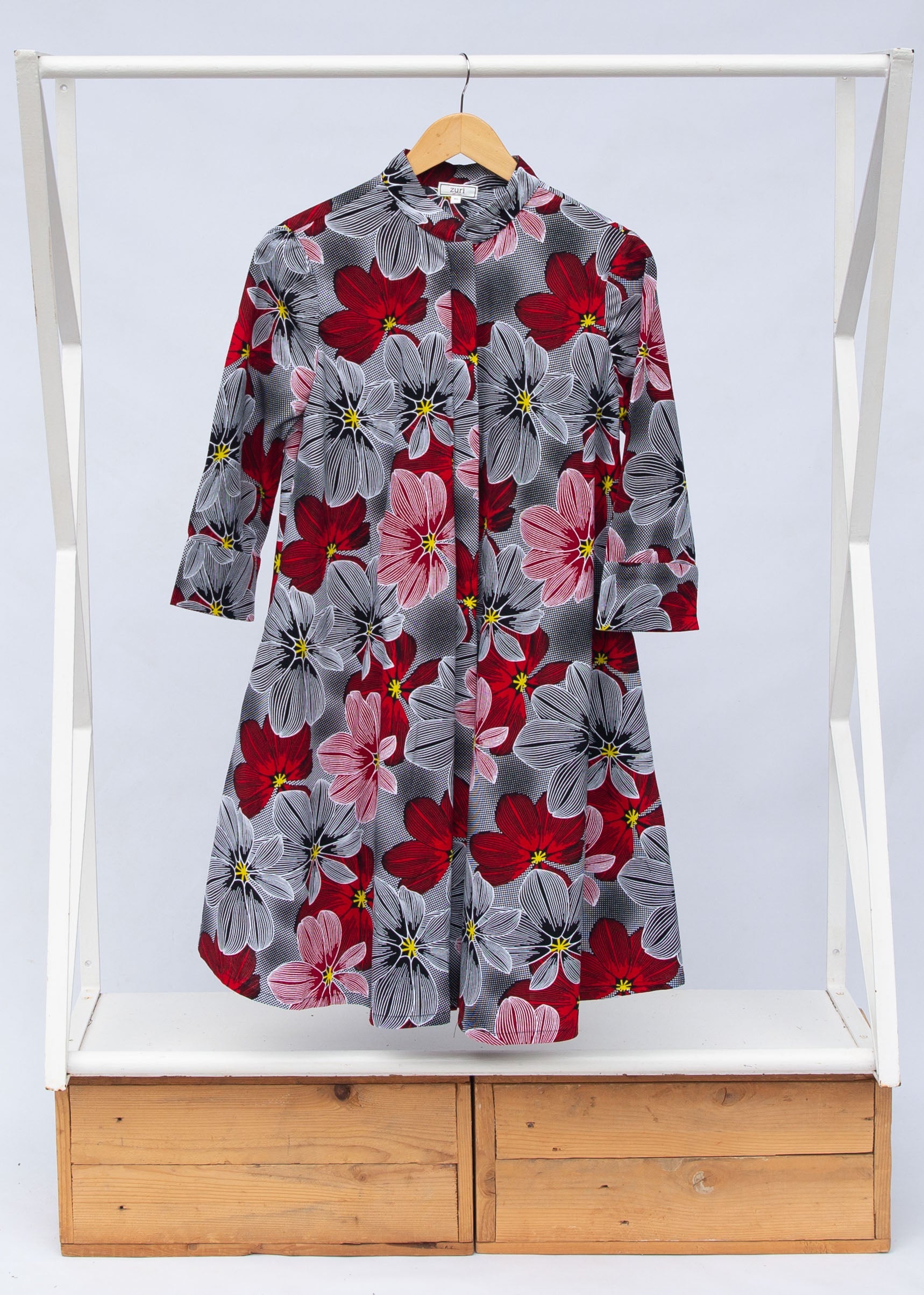 Display of dress with large grey and red flower print.