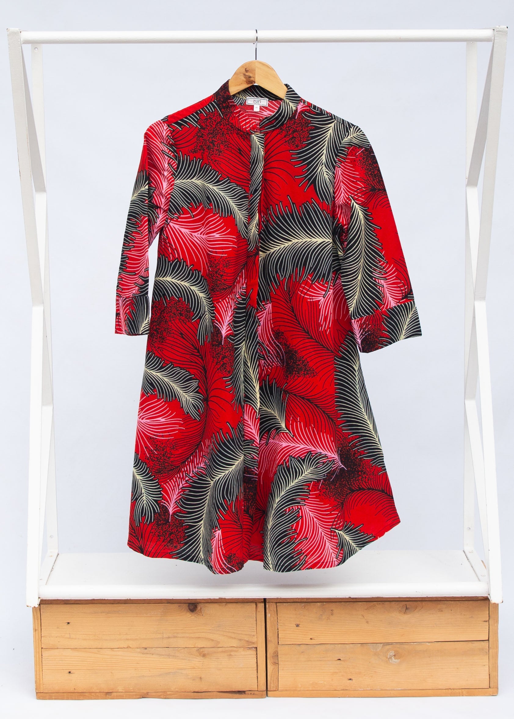 Display of red dress with black and white feather print.