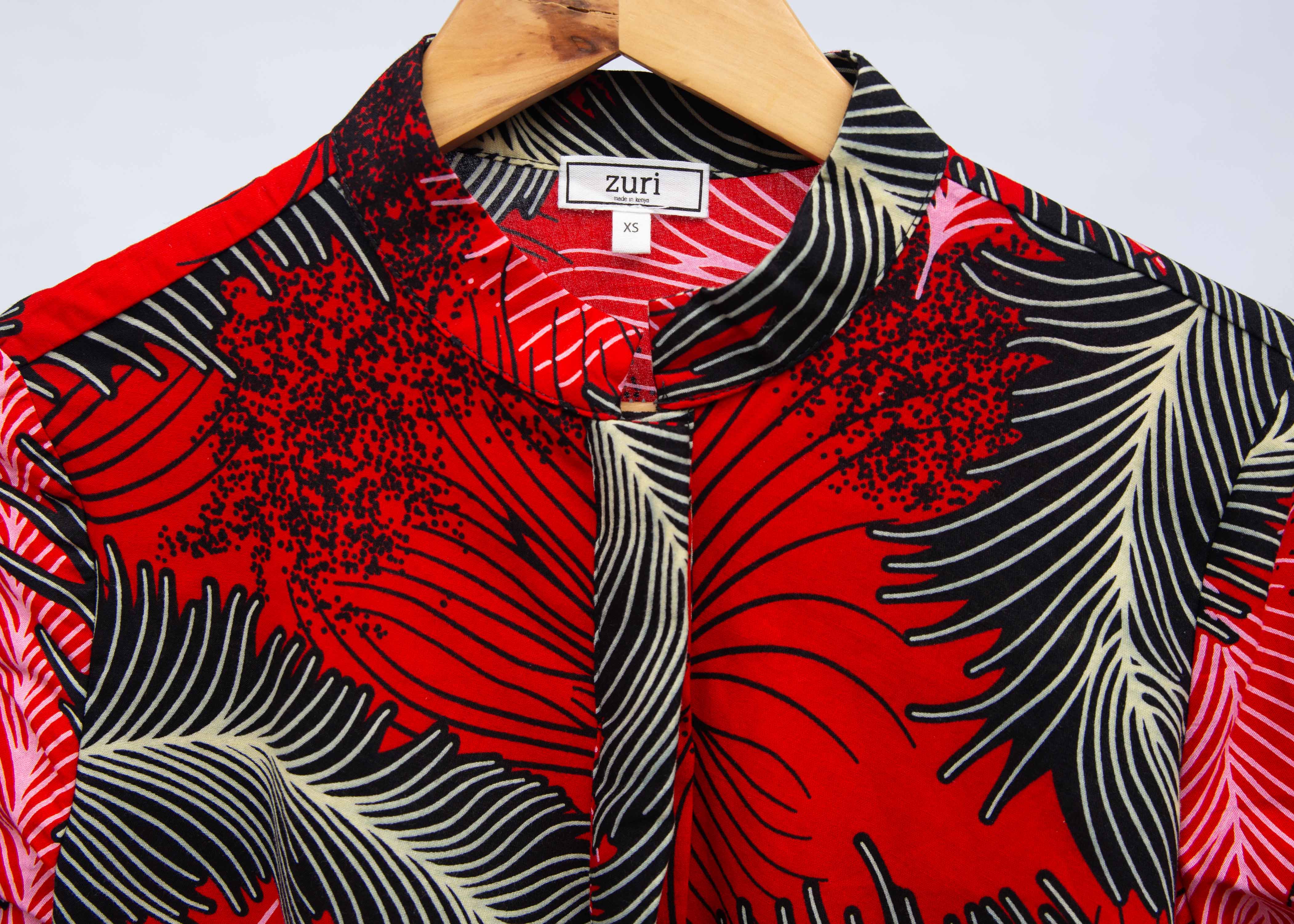 Display of red dress with black and white feather print.
