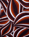 Close up display of brown, orange, burgundy and white abstract print dress, fabric.