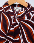 Display of brown, orange, burgundy and white abstract print dress.