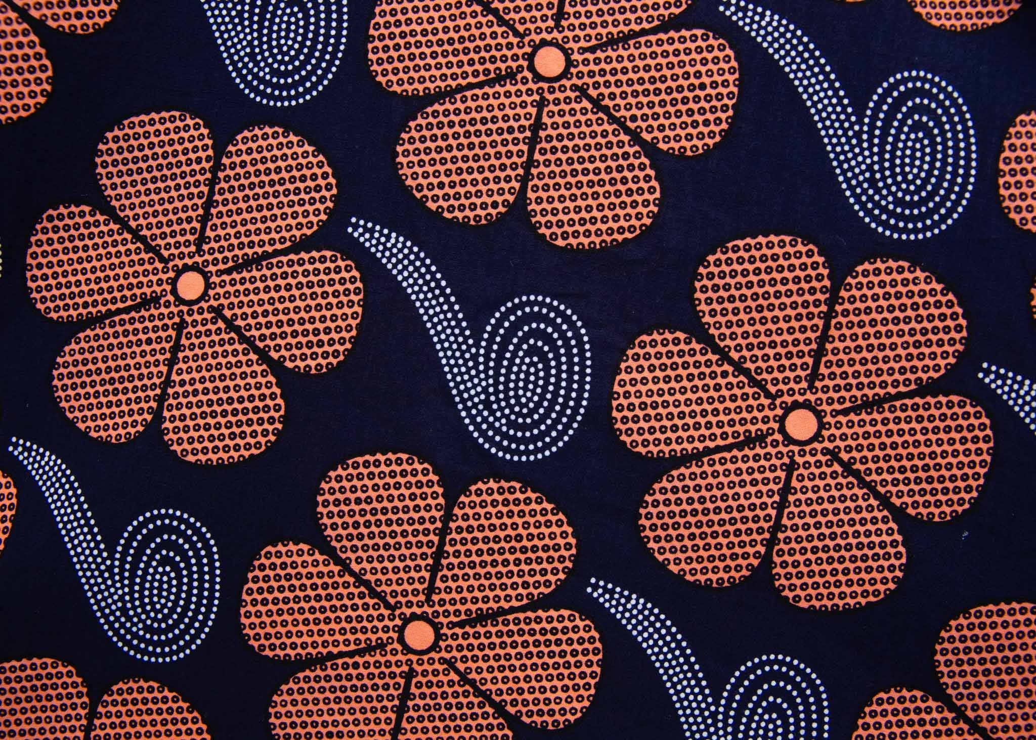 Close up Display of navy dress with brown flowers and white swirls, fabric.