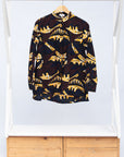 Display of long sleeve blouse with brown and yellow abstract print.