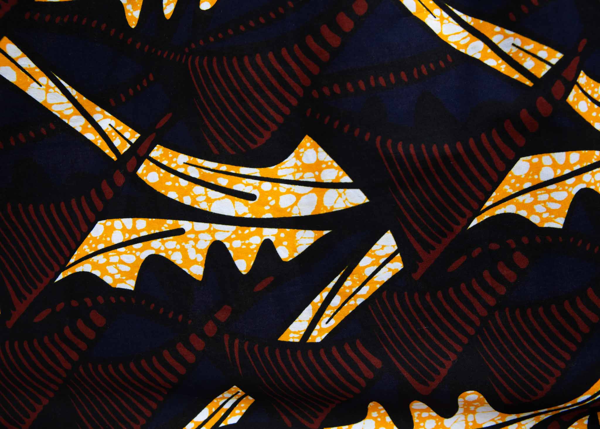 Display of long sleeve blouse with brown and yellow abstract print, fabric.