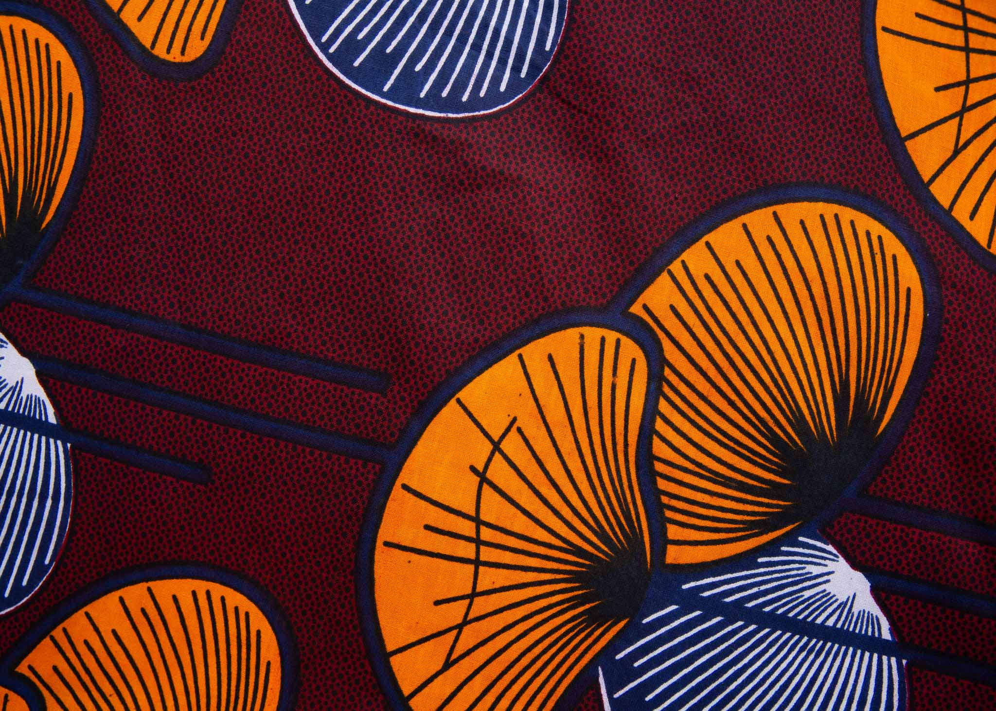 Close up display of burgundy sleeveless dress with yellow and white flowers, fabric.