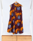 Display of burgundy sleeveless dress with yellow and white flowers.