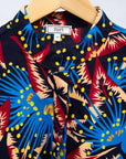 Display of black dress with blue, beige and red splatter print.