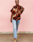 Model wearing beige shirt with brown and orange circles and lines.