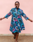 Model wearing black dress with colorful peacock print.