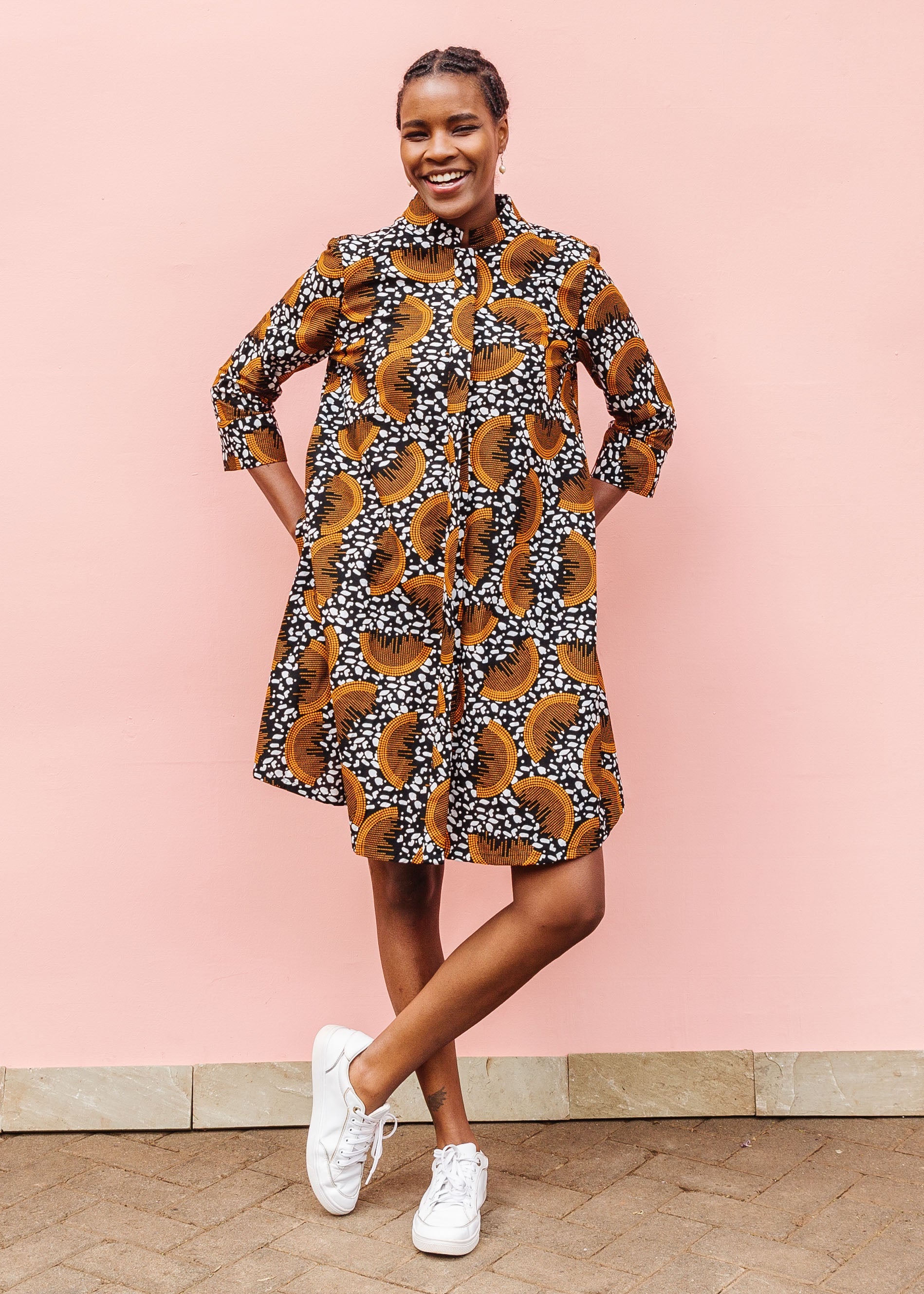 Model wearing black and white dress with orange half circle print.