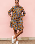 Model wearing black and white dress with orange half circle print.