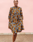 Model wearing black and white dress with orange half circle print.