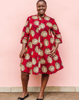 Model wearing red dress with brown feathers.
