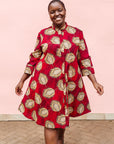 Model wearing red dress with brown feathers.
