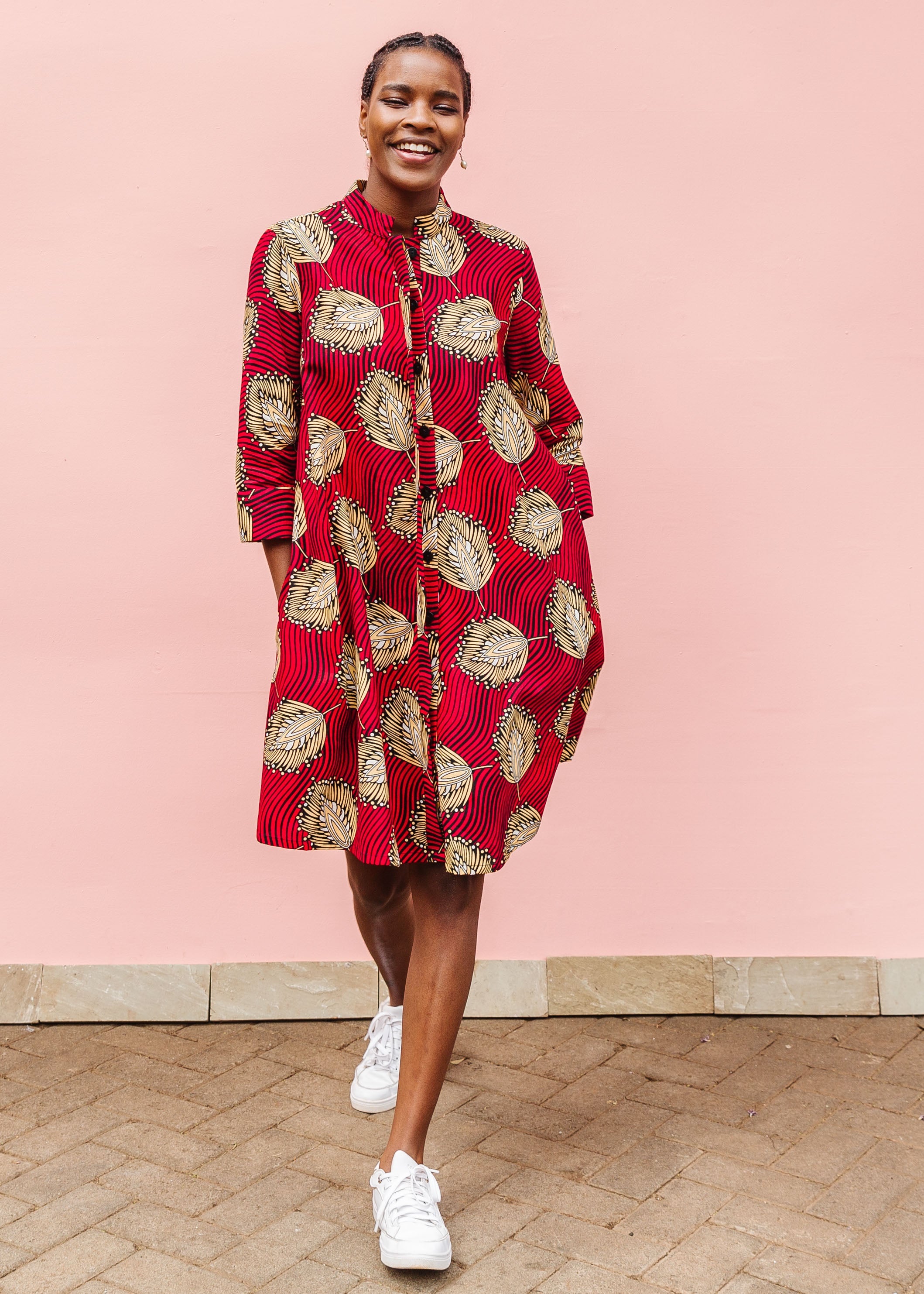 Model wearing red dress with brown feathers.