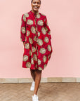 Model wearing red dress with brown feathers.