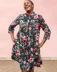 Model wearing black dress with white, green, red and yellow floral print.