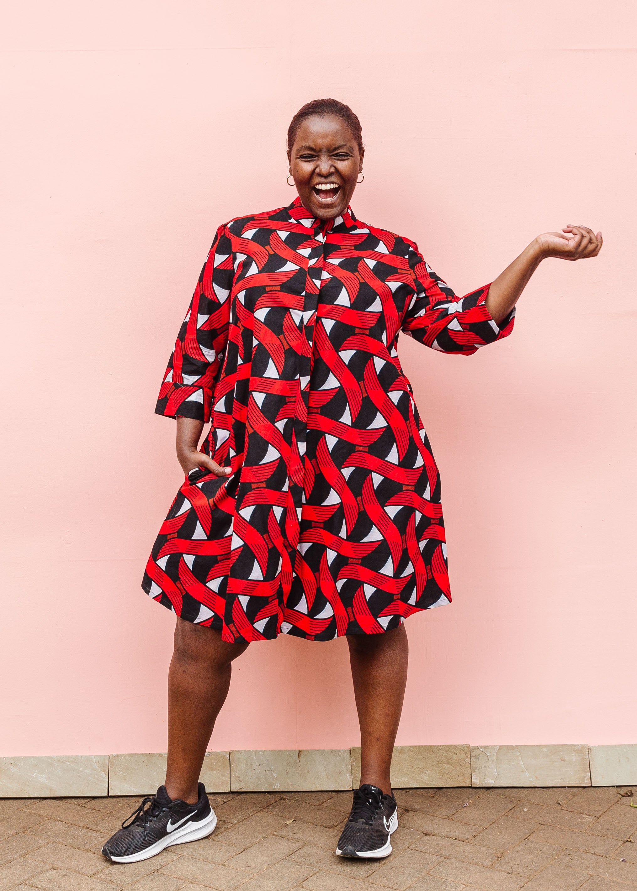 Model wearing red, black and white ribbon print dress.