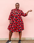 Model wearing red, black and white ribbon print dress.