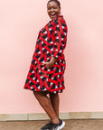 Model wearing red, black and white ribbon print dress.