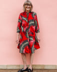 Model wearing red dress with black and white feather print.