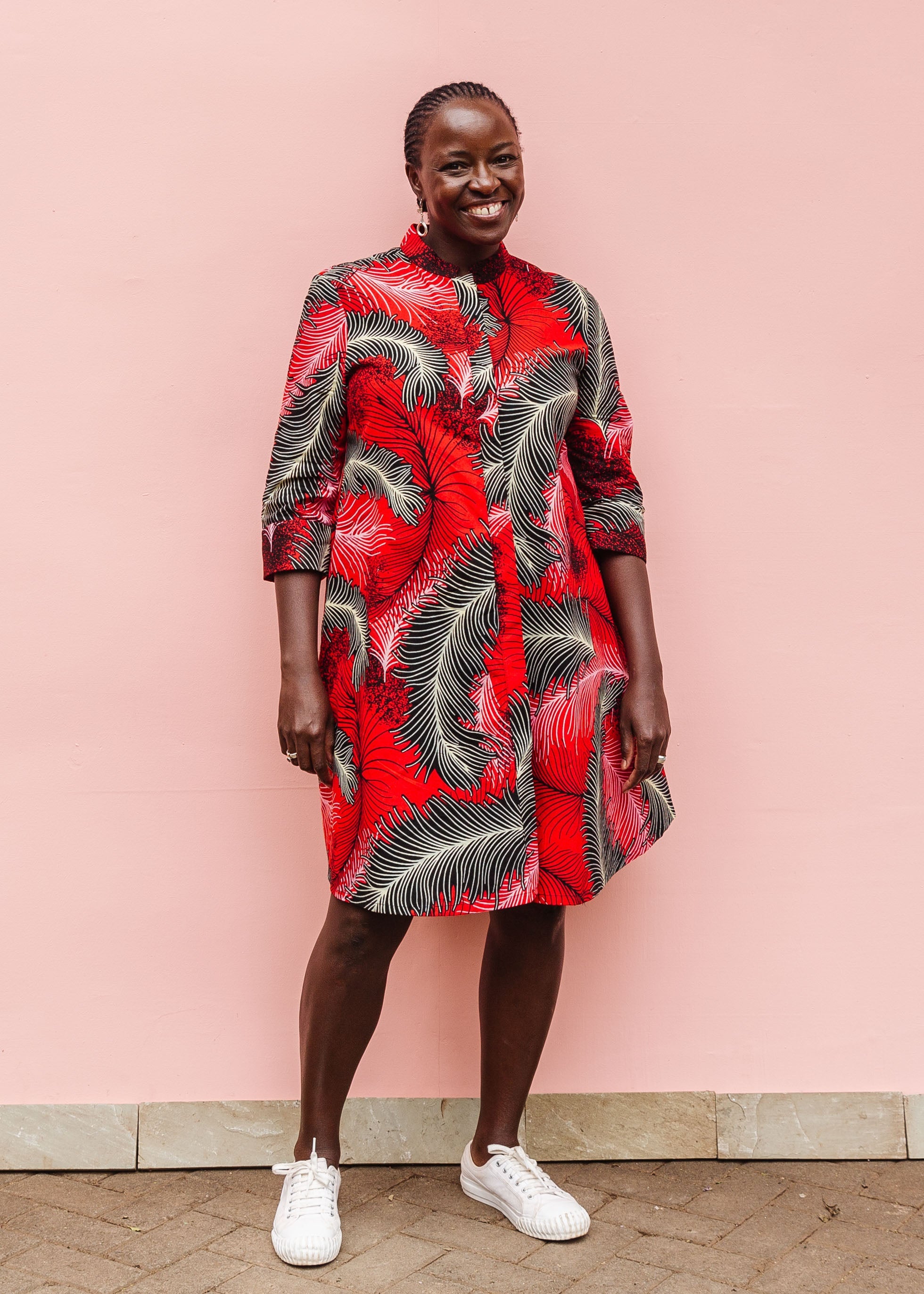 Model wearing red dress with black and white feather print.