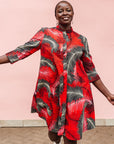 Model wearing red dress with black and white feather print.