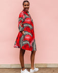 Model wearing red dress with black and white feather print.