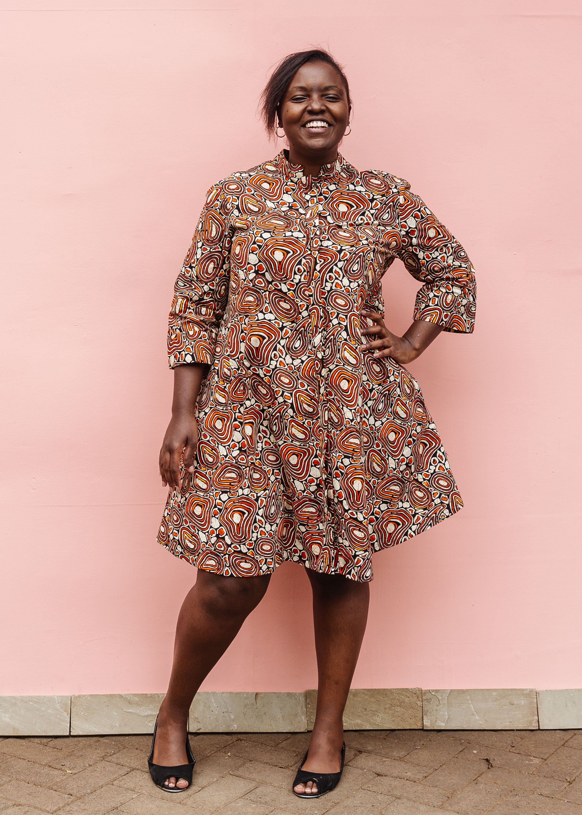 Model wearing brown, black and white pebble print dress.