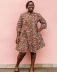 Model wearing brown, black and white pebble print dress.