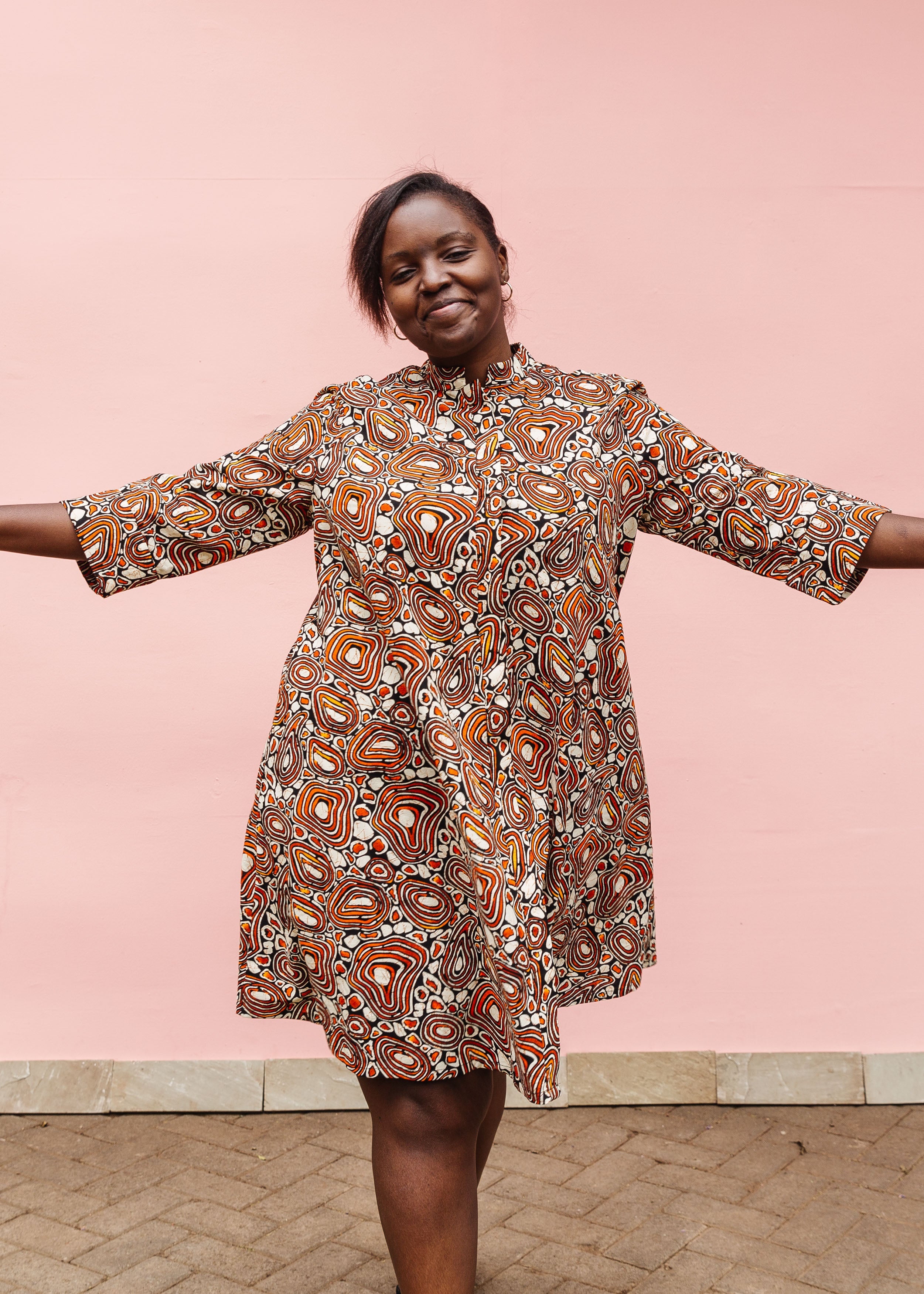 Model wearing brown, black and white pebble print dress.