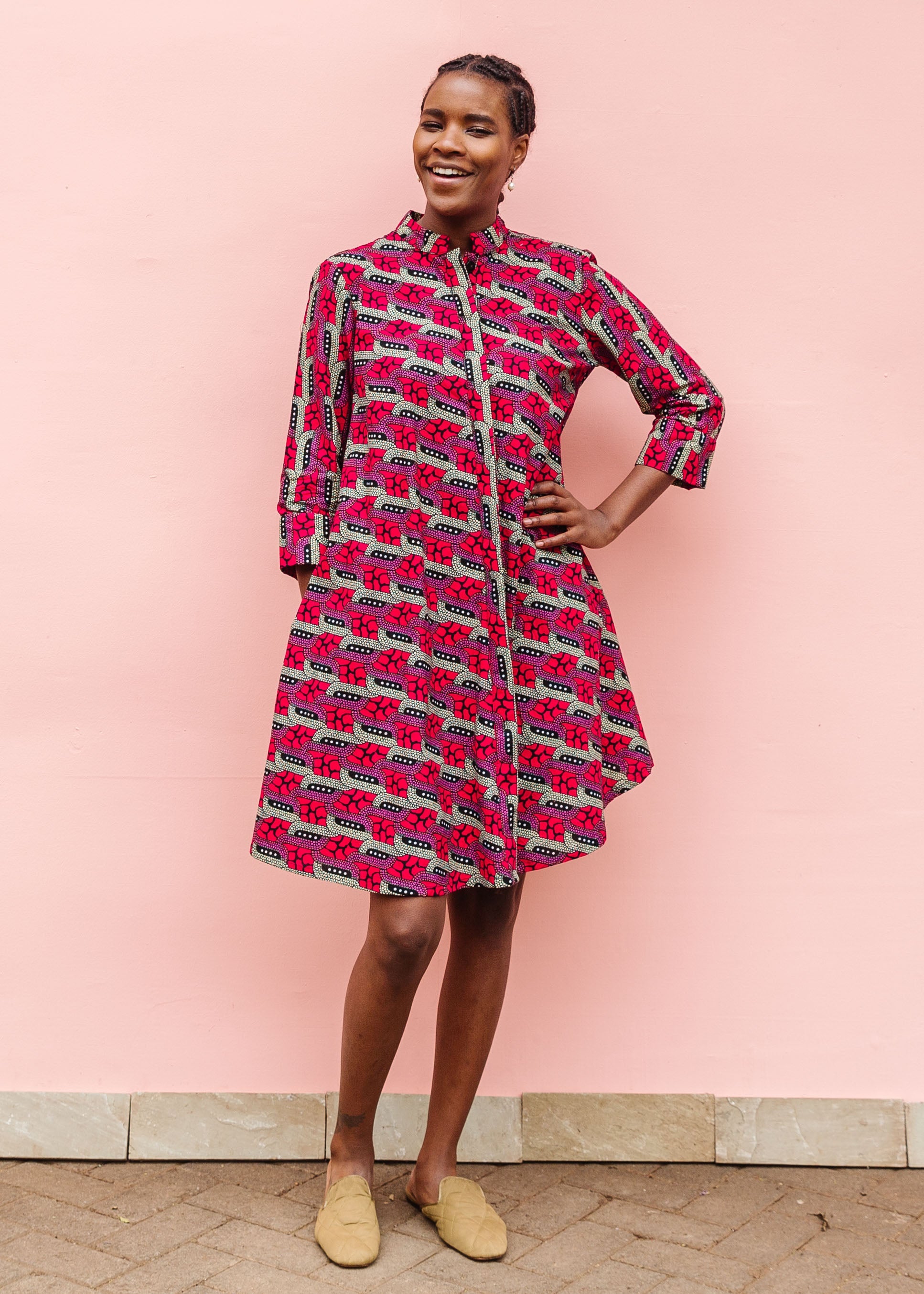 Model wearing red and pink geometric print dress.